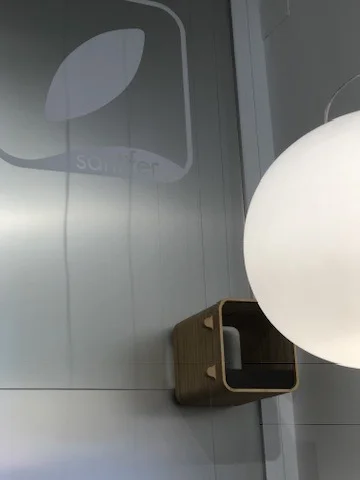 Wooden dumbwaiter next to spherical lamp and Jinank logo — connection between counter and workshop