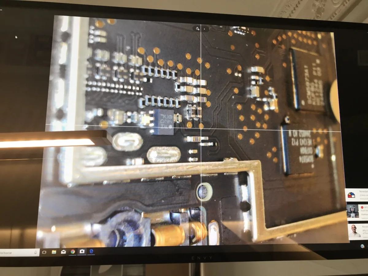 Technician working with microscope on PCB board